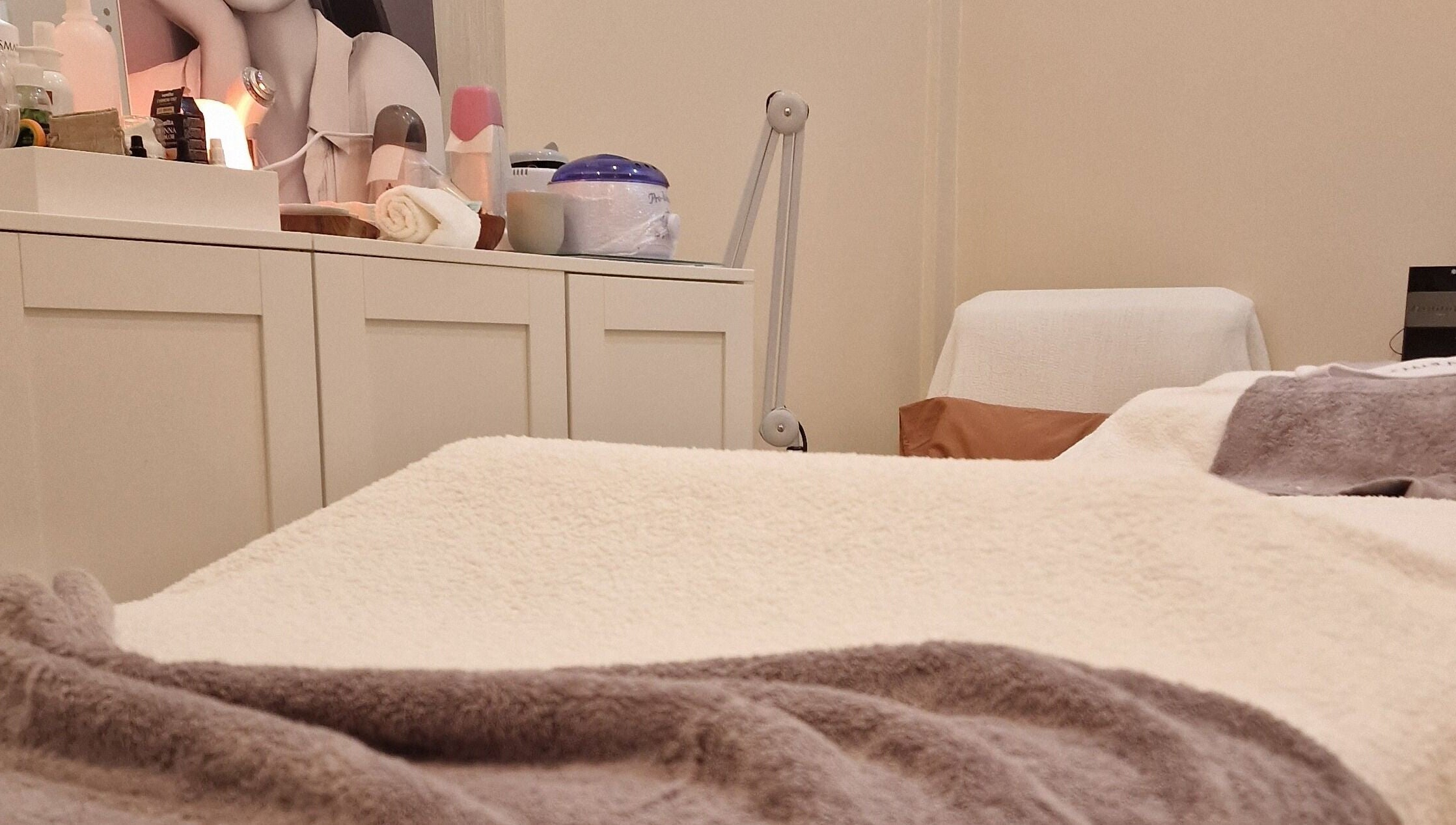 Ambiente acolhedor na Terapeuta Ana Martinez, Matosinhos, Porto, PT, com mesa de tratamento e produtos de beleza.