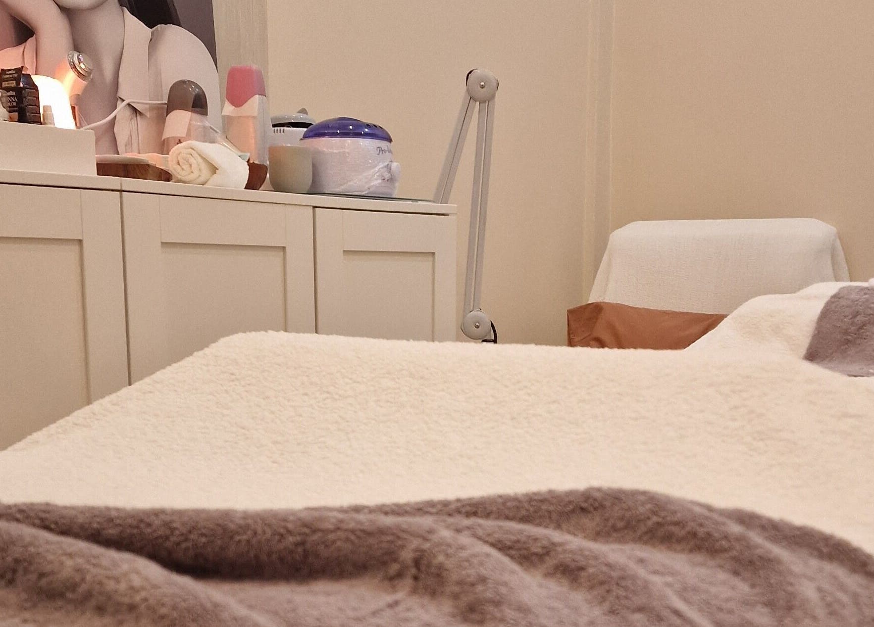 Ambiente acolhedor na Terapeuta Ana Martinez, Matosinhos, Porto, PT, com mesa de tratamento e produtos de beleza.