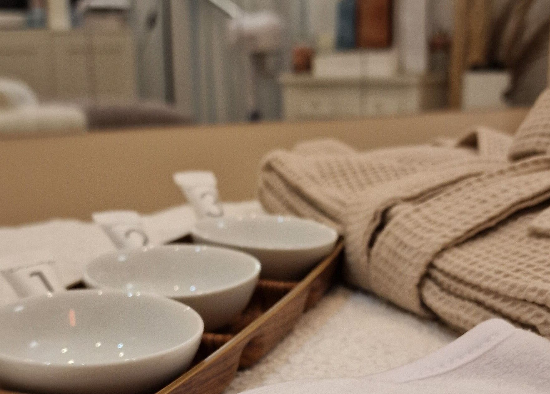 Ambiente relaxante com roupão e tigelas no spa Terapeuta Ana Martinez, Matosinhos, Porto, PT.