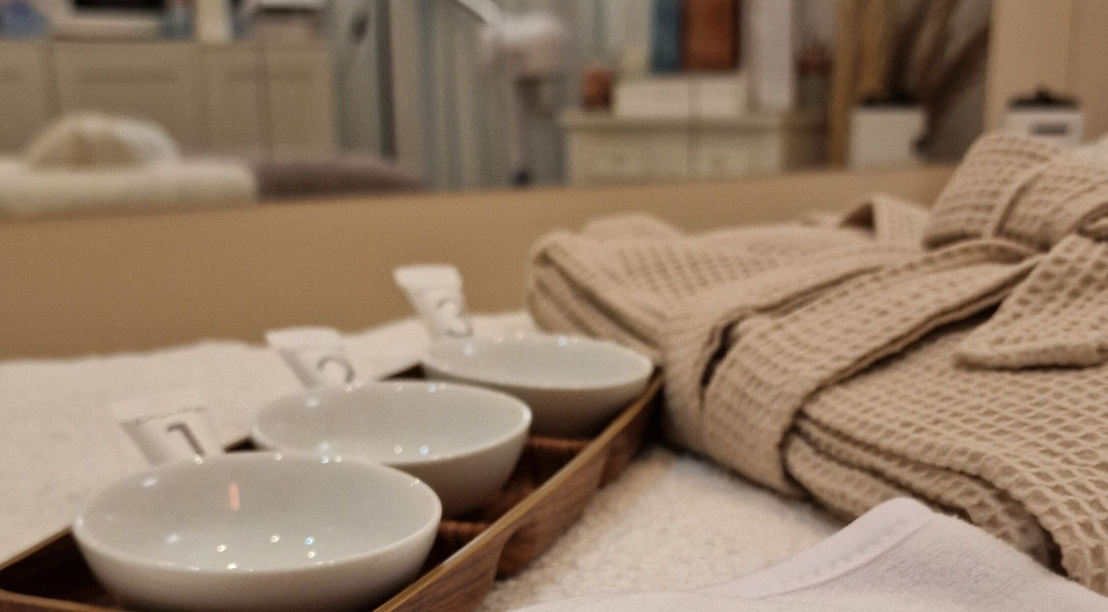 Ambiente relaxante com roupão e tigelas no spa Terapeuta Ana Martinez, Matosinhos, Porto, PT.