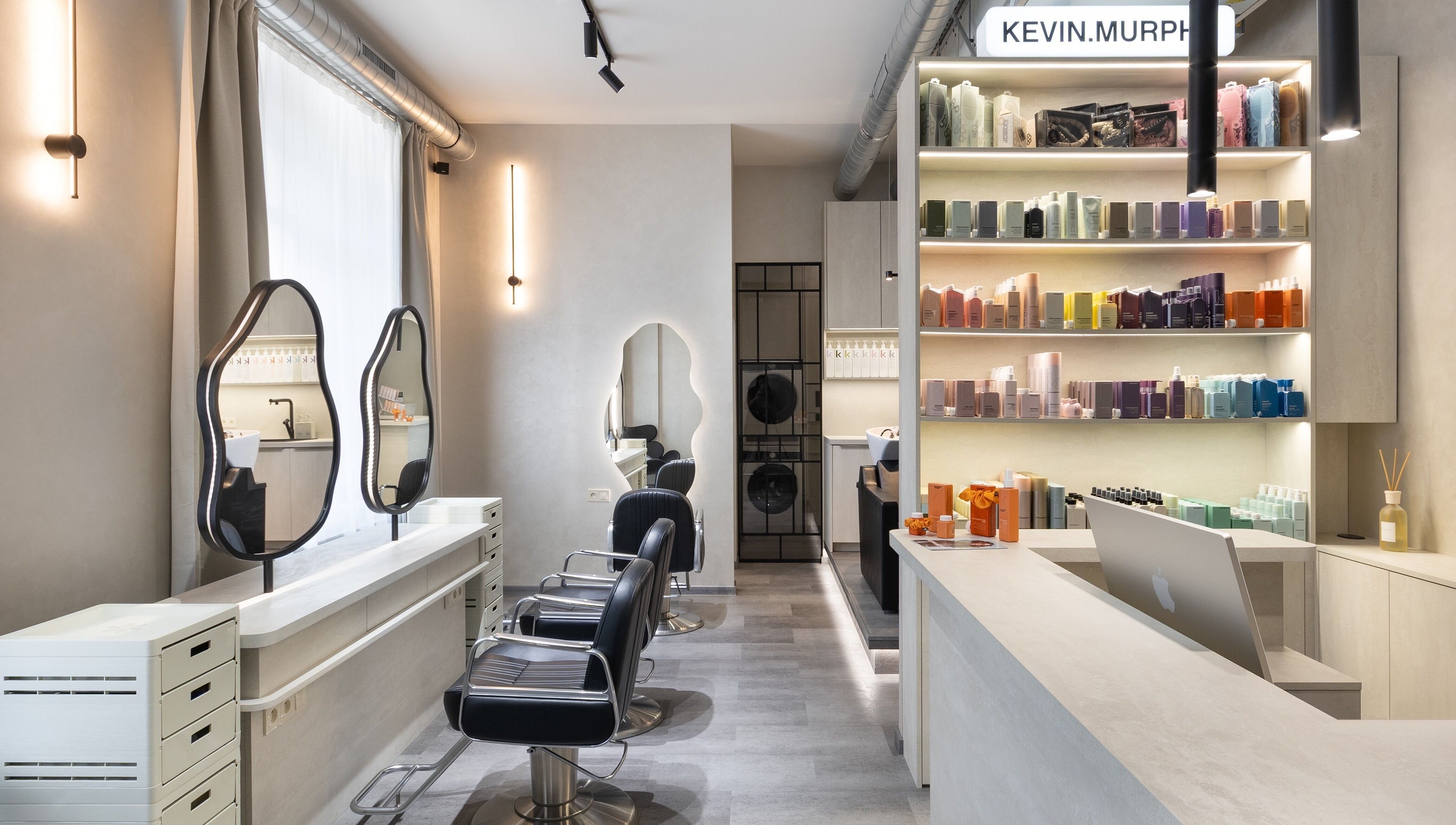 Moderní interiér salonu progress.hair v Hlavní Město Praha s elegantním nábytkem a produkty na policích.