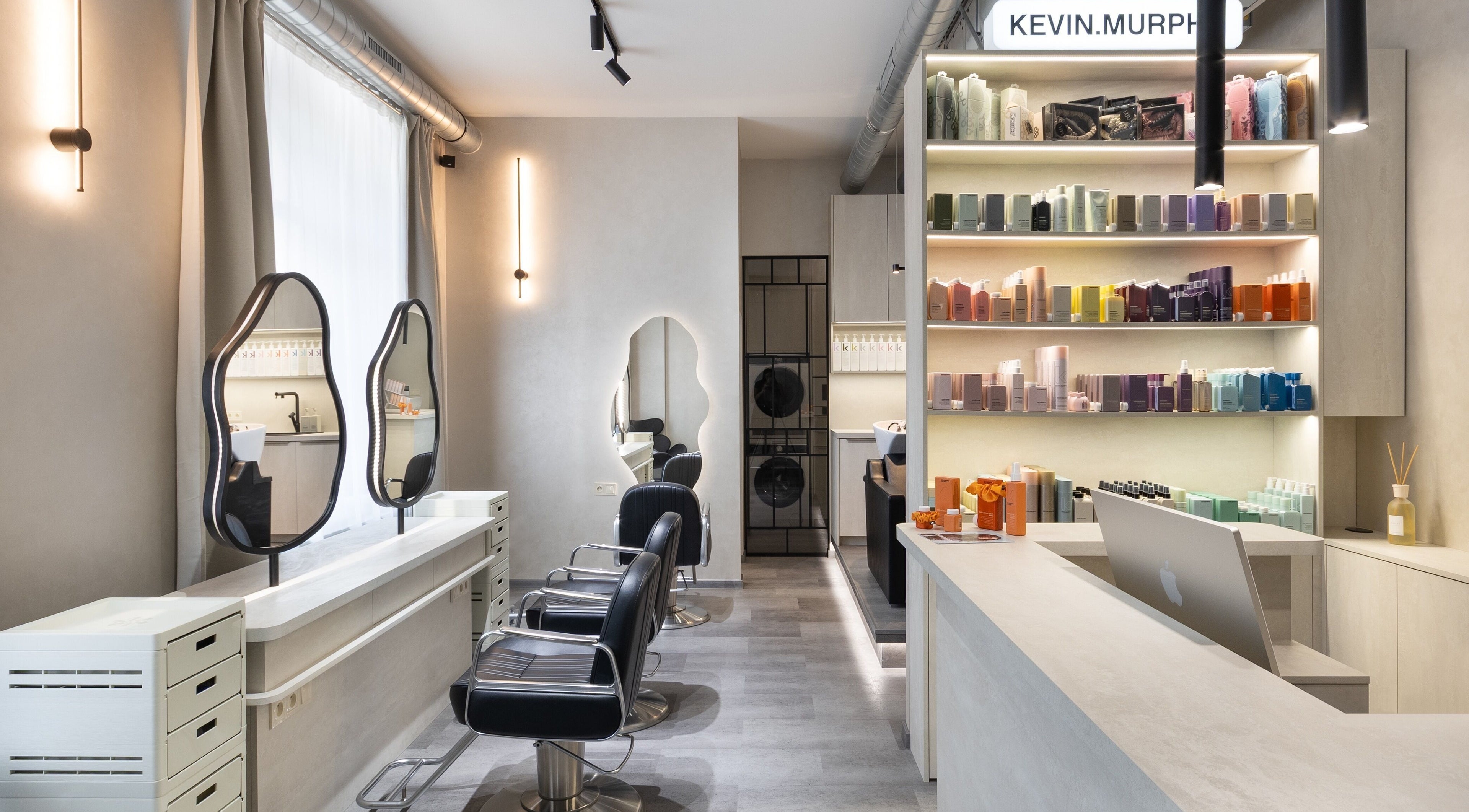 Moderní interiér salonu progress.hair v Hlavní Město Praha s elegantním nábytkem a produkty na policích.