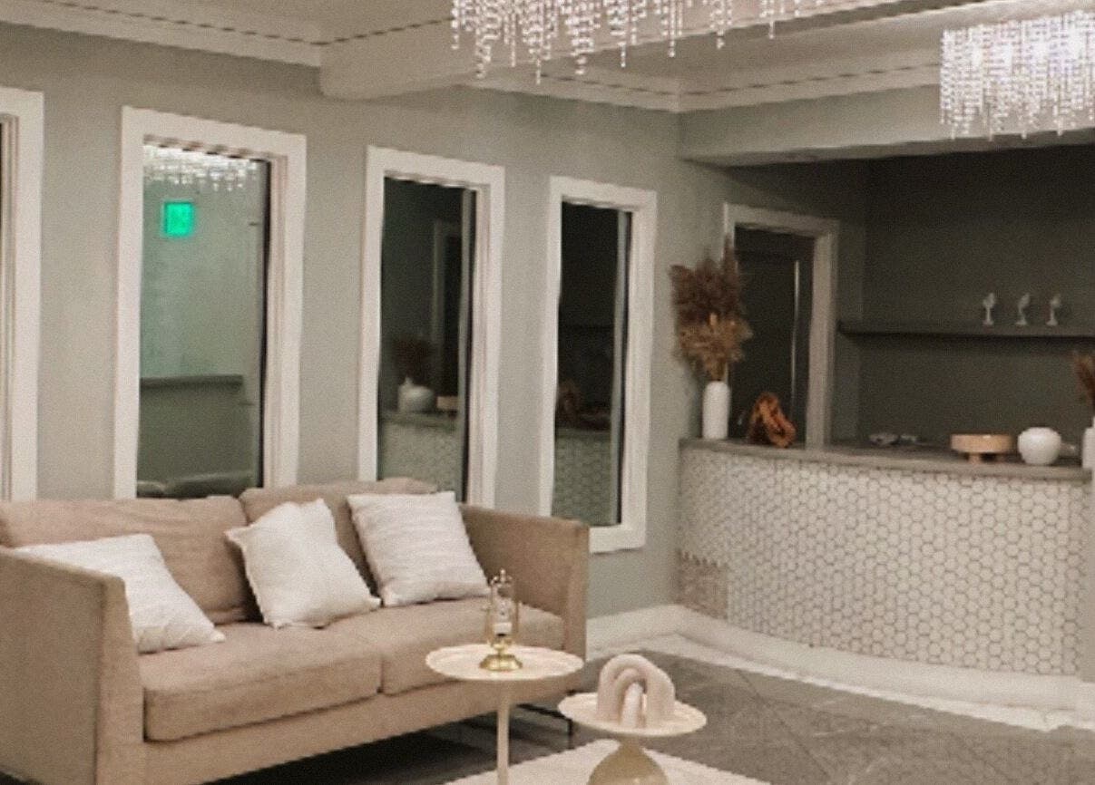 Elegante sala de recepción en Serenity Bloom Spa, Los Ángeles, California, US, con sofá y decoración luminosa.