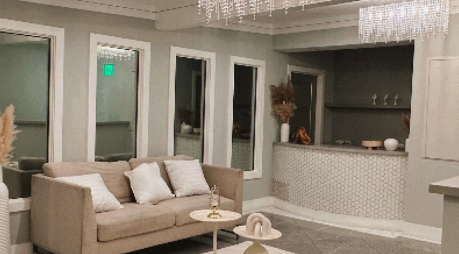 Elegante sala de recepción en Serenity Bloom Spa, Los Ángeles, California, US, con sofá y decoración luminosa.