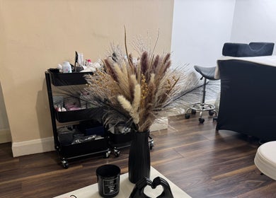 Cozy wellness corner at Beauty with CS, London, GB featuring stylish decor and floral arrangement.