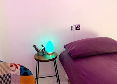 Peaceful therapy room at Reflexology and Scar Release by Nadine in Norwich, England, GB with purple bedding.