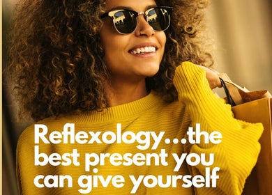 Smiling woman in yellow sweater with shopping bags at Reflexology and Scar Release by Nadine, Norwich, England, GB.