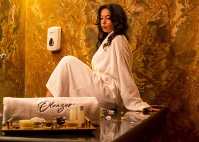Femme détendue au spa Oleazen à Casablanca, Casablanca-settat, MA, en robe blanche sur fond de marbre.