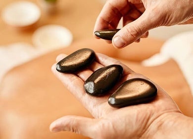 Relaxing hot stone massage at Nella Fusco LMT, CSP in Waterville, Maine, US, enhancing wellness and tranquility.