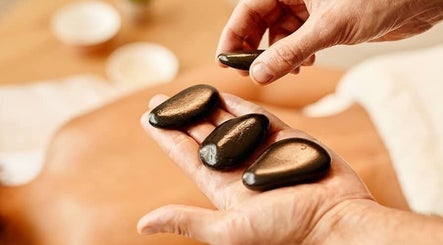 Relaxing hot stone massage at Nella Fusco LMT, CSP in Waterville, Maine, US, enhancing wellness and tranquility.