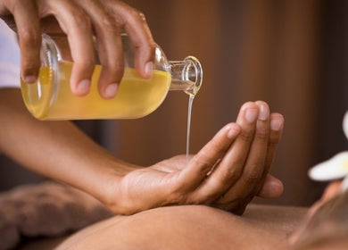 Massage oil being poured for relaxation at Nella Fusco LMT, CSP in Waterville, Maine, US.