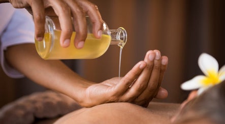 Massage oil being poured for relaxation at Nella Fusco LMT, CSP in Waterville, Maine, US.