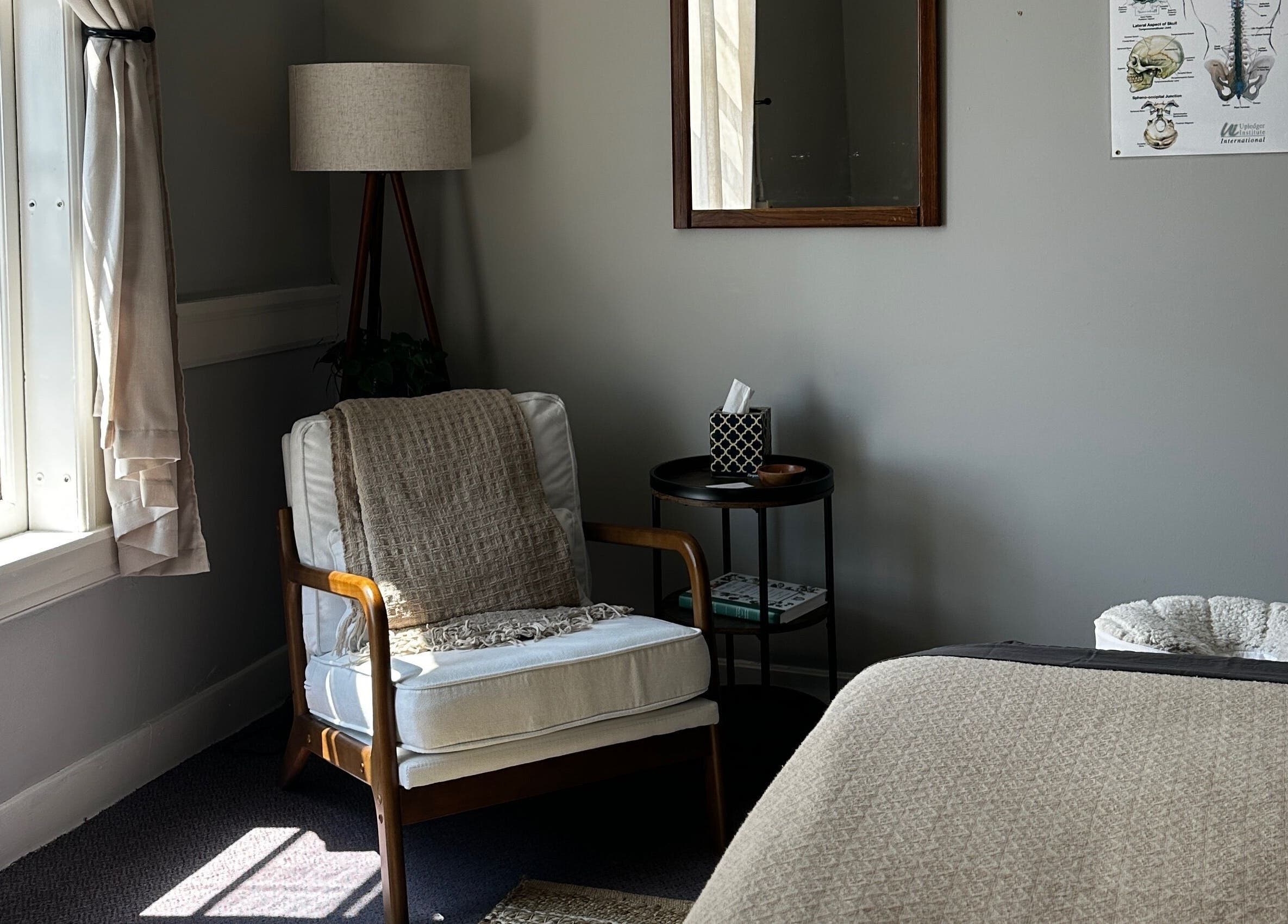Inviting relaxation area at Nella Fusco LMT, CSP in Waterville, Maine, US with a cozy chair and soft lighting.