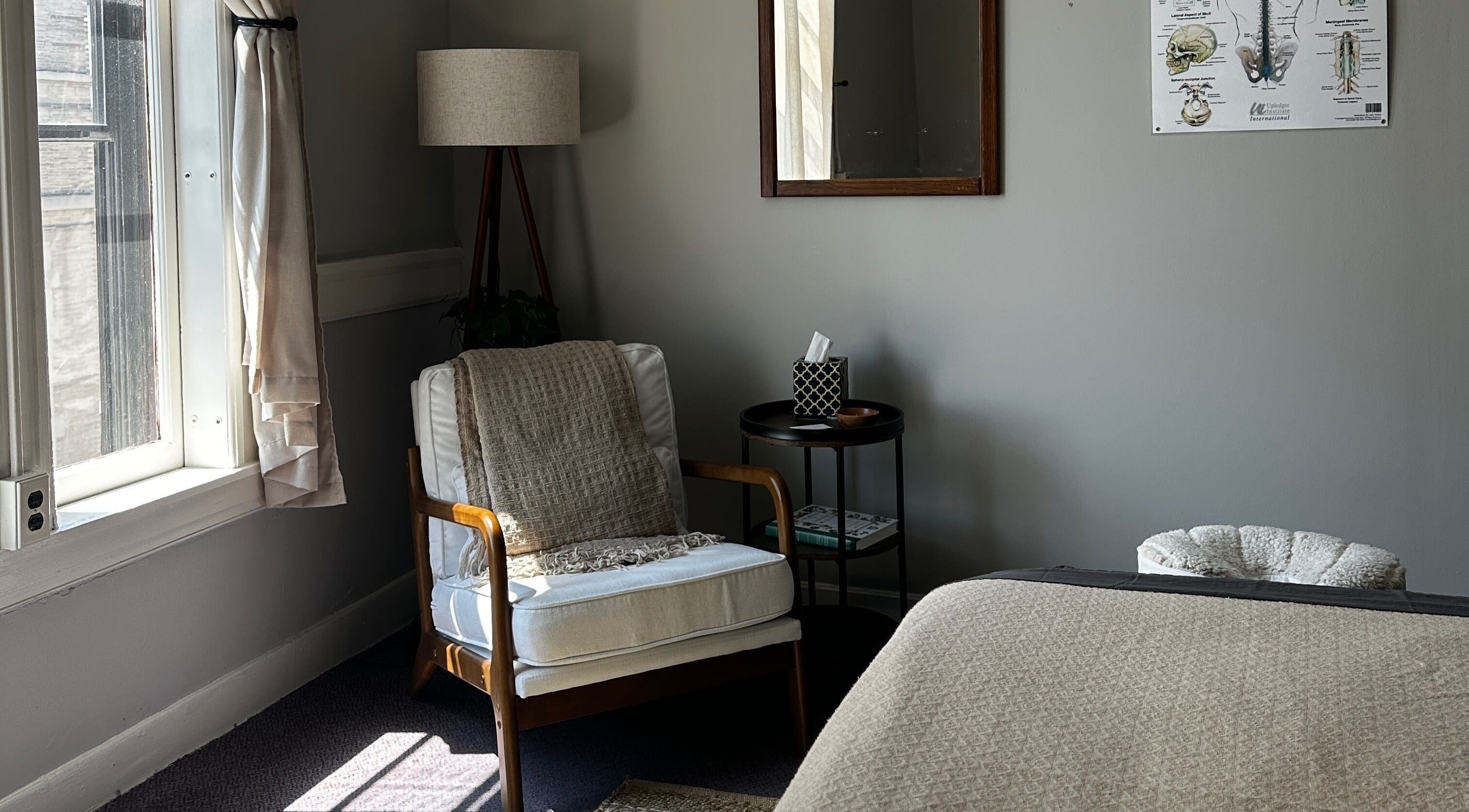 Inviting relaxation area at Nella Fusco LMT, CSP in Waterville, Maine, US with a cozy chair and soft lighting.