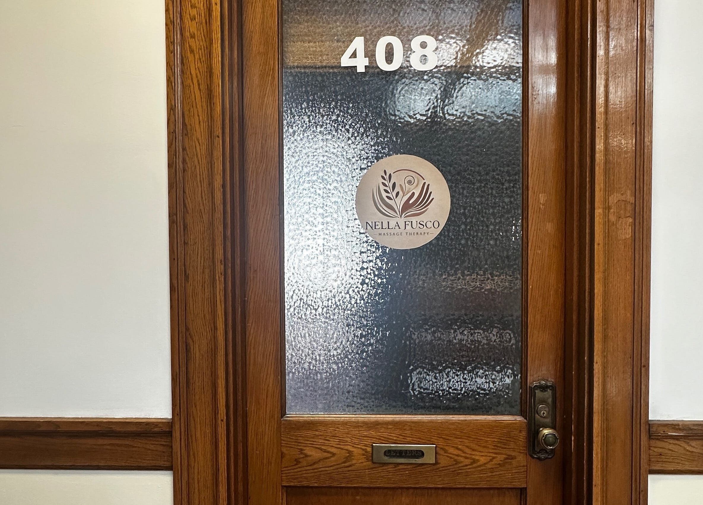 Entrance to Nella Fusco LMT, CSP office in Waterville, Maine with wooden frame and frosted glass.