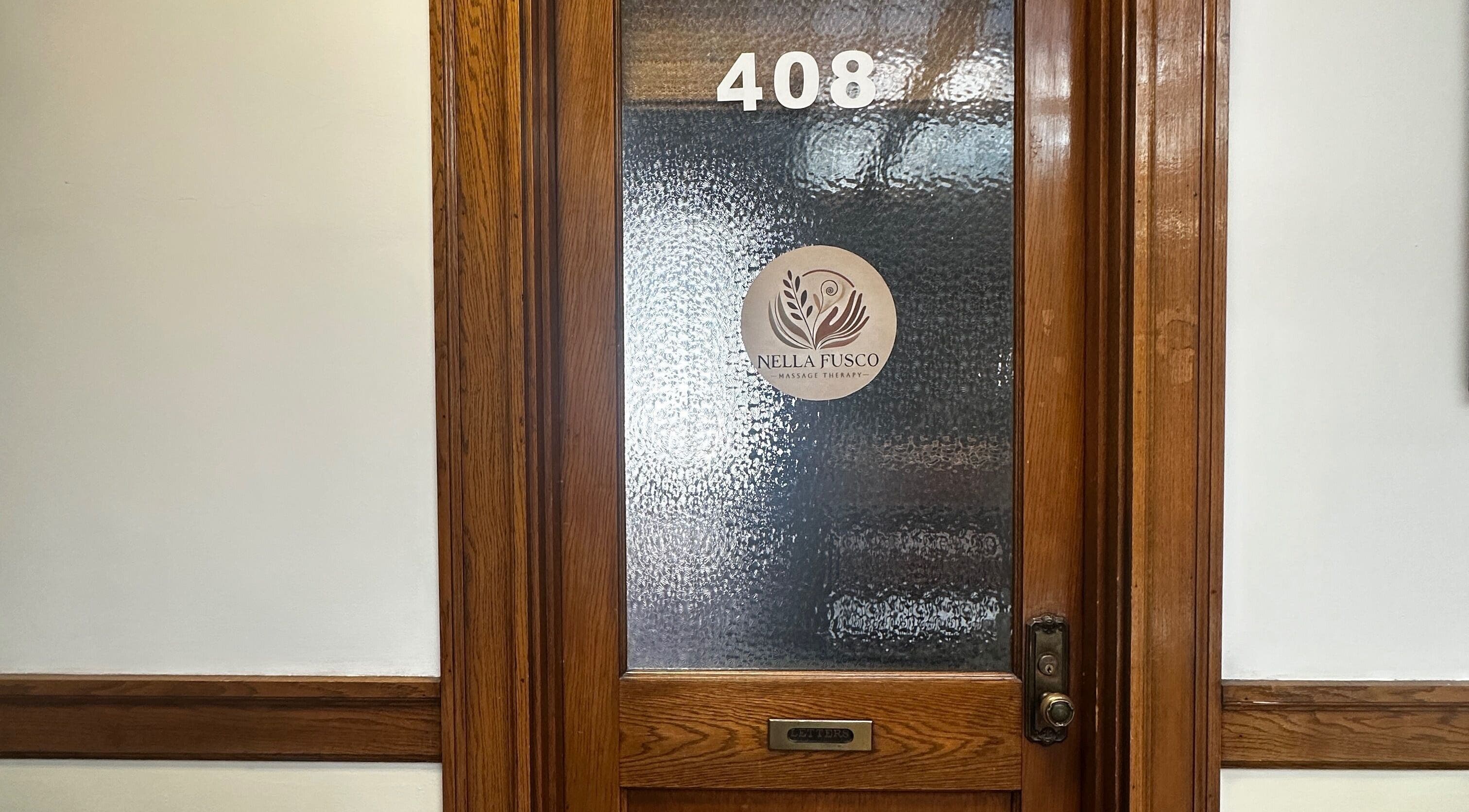 Entrance to Nella Fusco LMT, CSP office in Waterville, Maine with wooden frame and frosted glass.