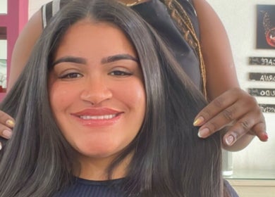 Cliente sorrindo no Laíse Black Studio, em São Paulo, São Paulo, BR, com cabelo liso e brilhante.