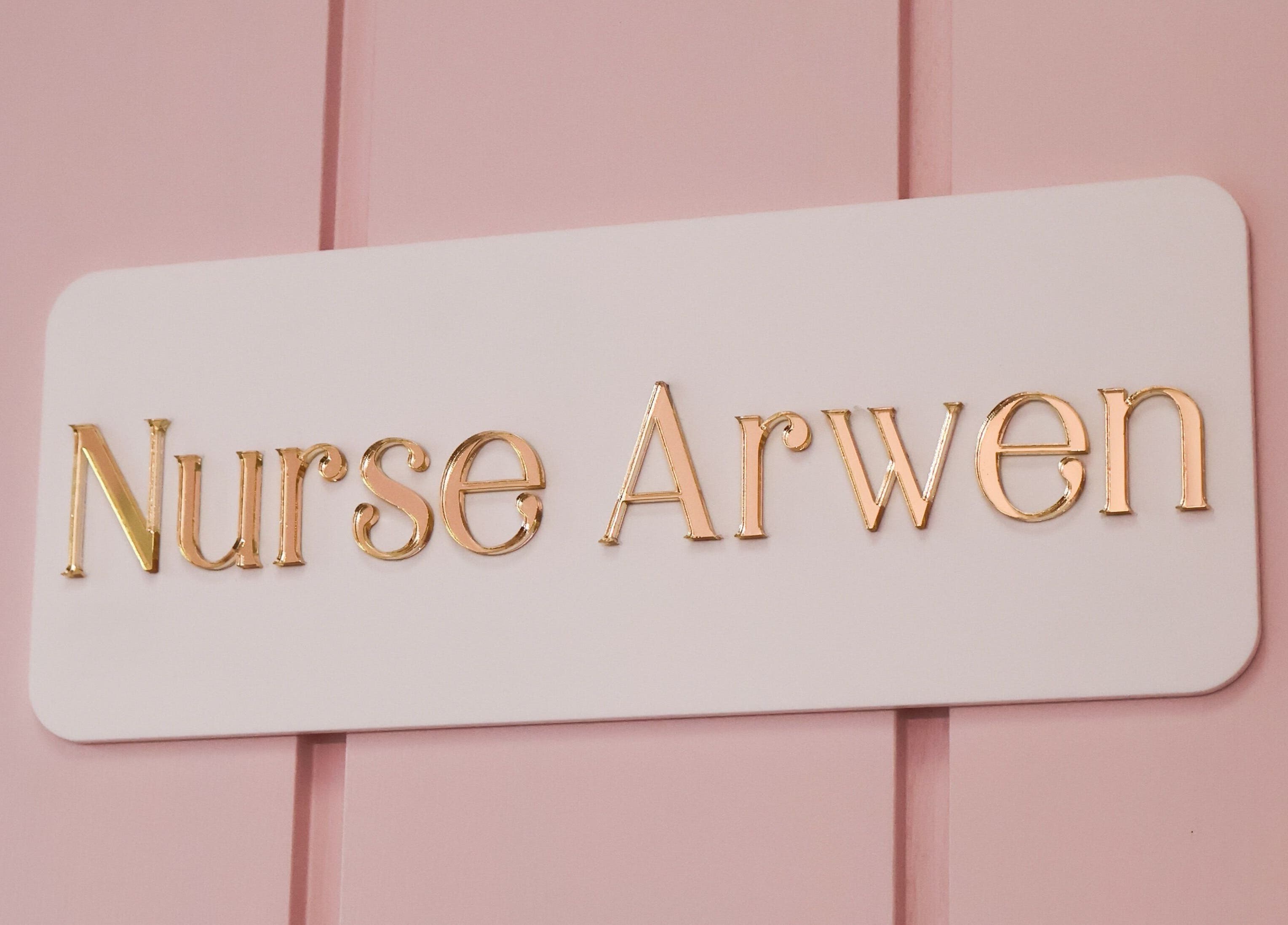 Elegant sign reading 'Nurse Arwen' at The Blossom Clinic, Beccles, England, GB, on a pink background.