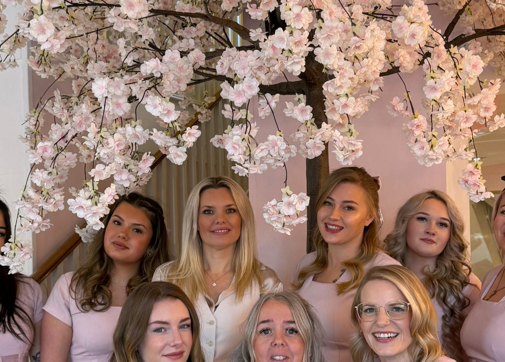 Team at The Blossom Clinic, Beccles, England under cherry blossoms. Warm and welcoming ambiance.