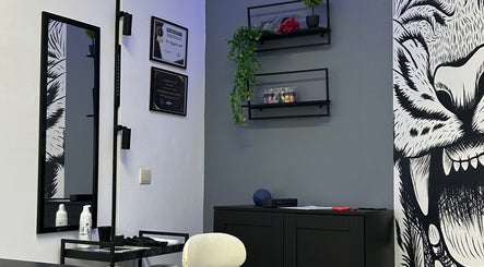 Interior moderno do Nivia Mendes Ink Tatto em Forest, Bruxelles, BE, com decoração elegante e certificados na parede.