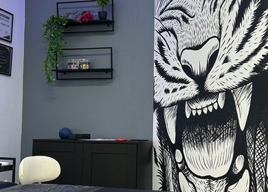 Interior do estúdio Nivia Mendes Ink Tatto em Forest, Bruxelles, BE, com arte de tigre impressionante na parede.