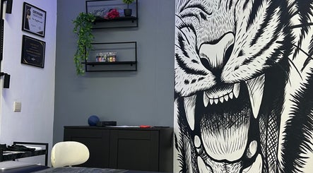 Interior do estúdio Nivia Mendes Ink Tatto em Forest, Bruxelles, BE, com arte de tigre impressionante na parede.