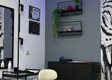 Interior decorado do estúdio Nivia Mendes Ink Tatto em Forest, Bruxelles, BE, com prateleiras e arte de parede.