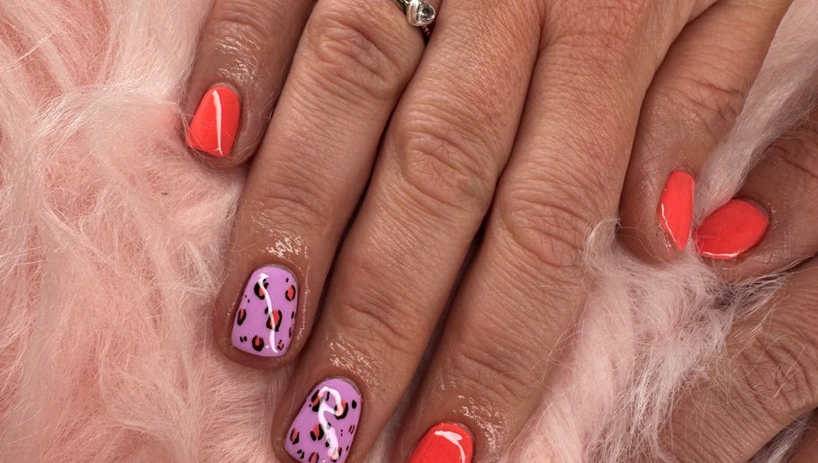 Vibrant nail art with pink and orange polish at Dazzling Beauty, King's Lynn, England, GB.