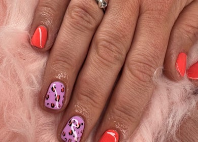 Vibrant nail art with pink and orange polish at Dazzling Beauty, King's Lynn, England, GB.