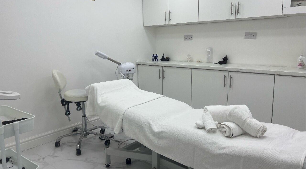 Serene treatment room at JA Sports Injuries in Oldbury, England, GB, featuring a white massage bed and clean decor.