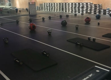 Fitness equipment setup at JA Sports Injuries, Oldbury, England, GB gym. Kettlebells and medicine balls are visible.