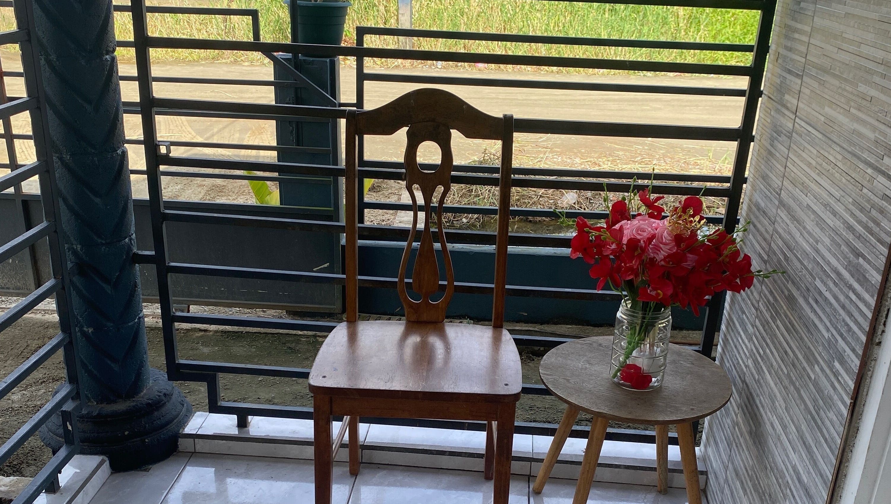 Wooden chair and vibrant flowers on Aesthetic Pampering terrace, Paramaribo, Paramaribo, SR.