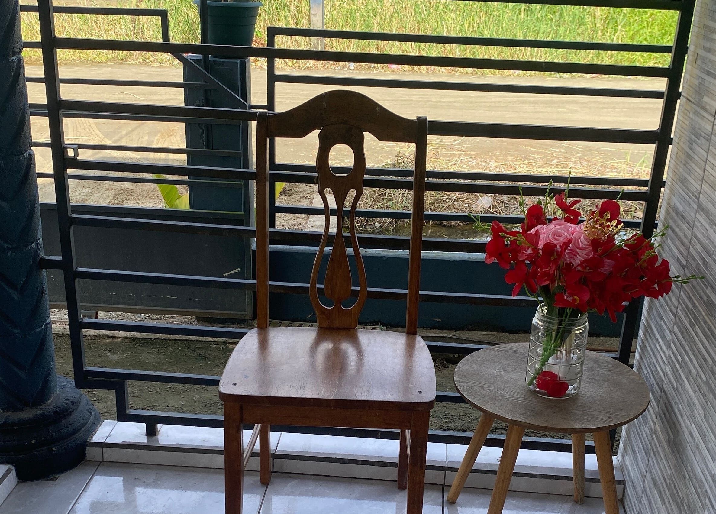 Wooden chair and vibrant flowers on Aesthetic Pampering terrace, Paramaribo, Paramaribo, SR.