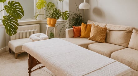 Relaxing massage room at Natural Body Massage, Glasgow, Scotland, GB with plants and cozy seating.