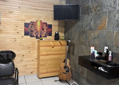 Interior moderno do Bruno Santos Barbershop em Minas Gerais, com decoração aconchegante e guitarra.