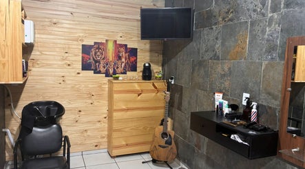Interior moderno do Bruno Santos Barbershop em Minas Gerais, com decoração aconchegante e guitarra.