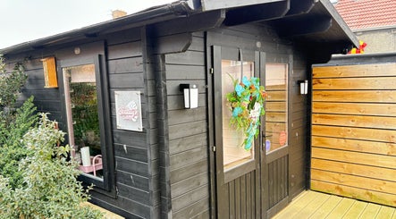 Cozy exterior of The Little Beauty Cabin in Hadston, England, showcasing a welcoming entrance.