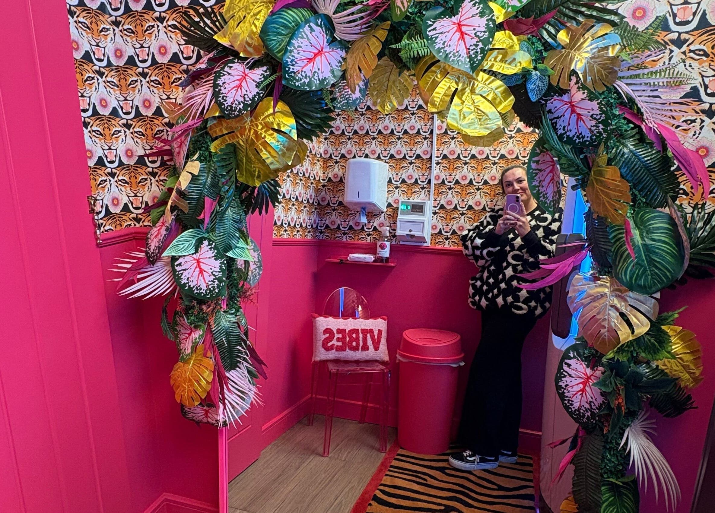 Vibrant decor at The Little Beauty Cabin, Hadston, England, GB, featuring lush floral arch and bold patterns.