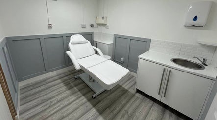 Calm treatment room at Aceso Aesthetics in Northwich, England, GB, featuring a comfortable white chair and modern decor.