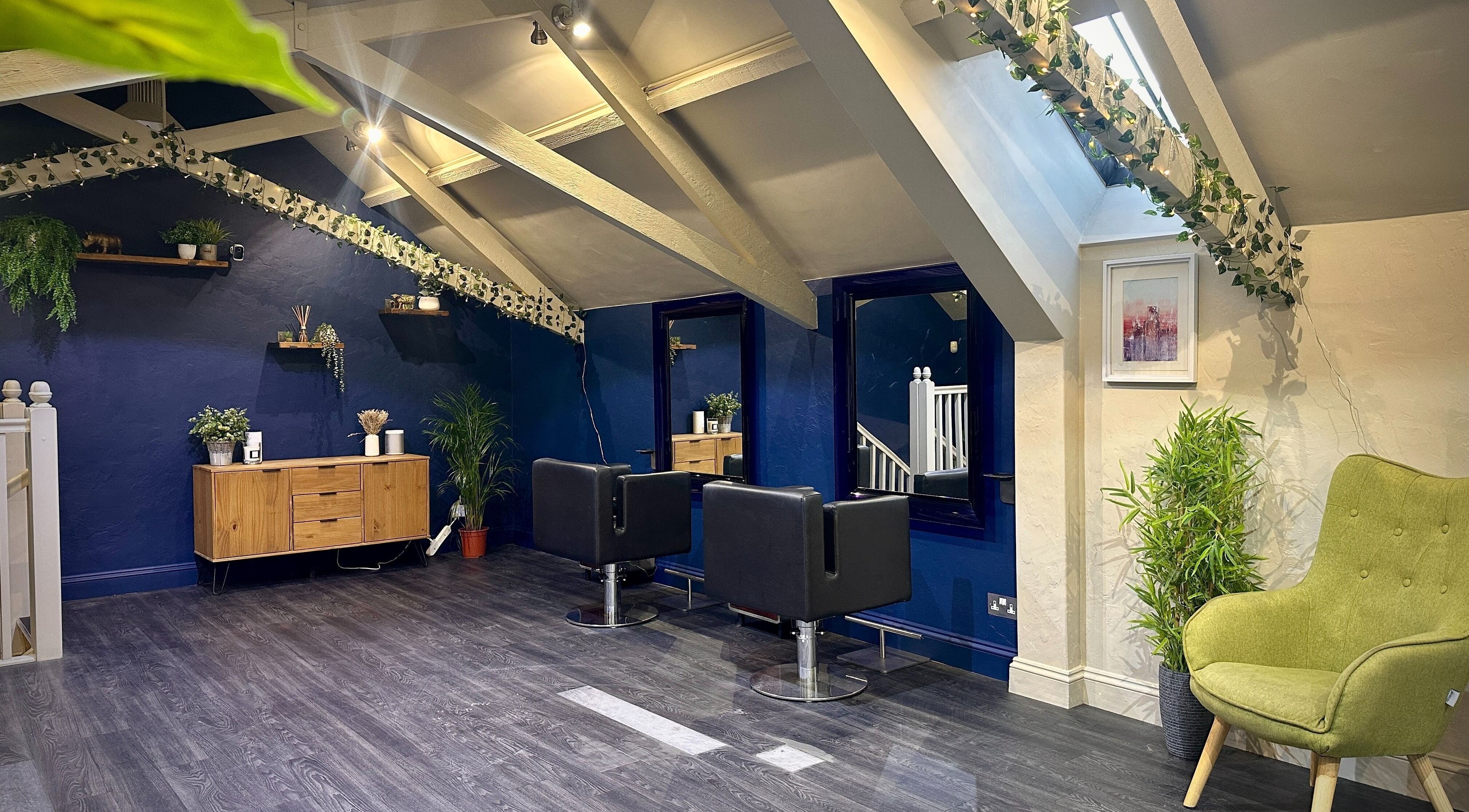 Chic interior of Apple Hair Design, Holt, England, GB with modern chairs and lush greenery.