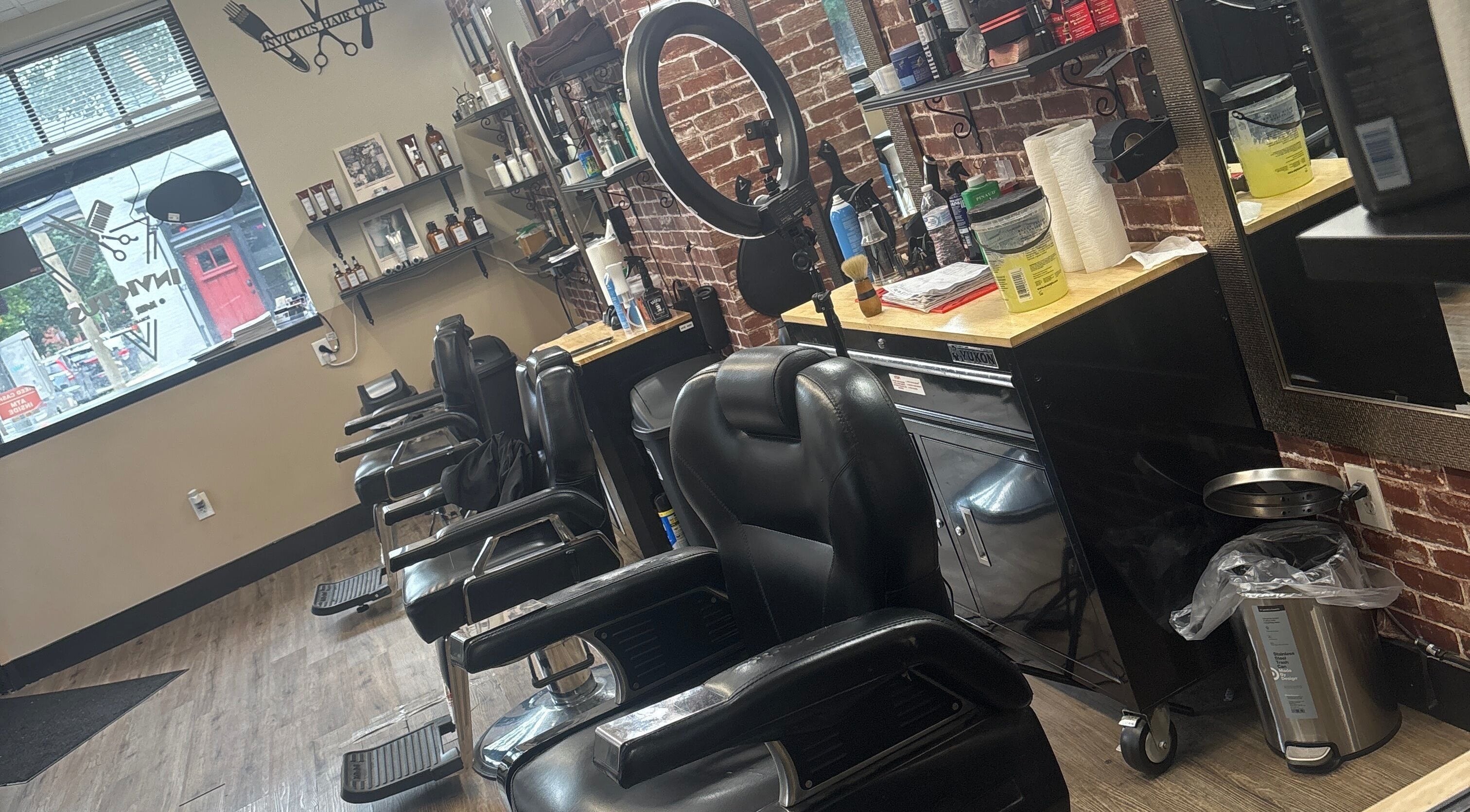 Inside Invictus Barbershop in Lancaster, Pennsylvania, US. Modern chairs and tools line the stylish brick wall.