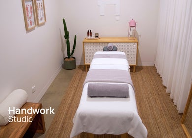 Tranquil massage room at Handwork Studio, Windsor, Victoria, AU, featuring a neatly made bed and minimalist decor.