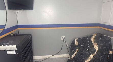 Cozy corner at Daniel M Barbershop, Ashland, Massachusetts, US with TV and stylish decor.