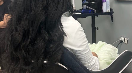 Woman with flowing black hair seated at Hairbystellalalo, Long Branch, New Jersey, US.