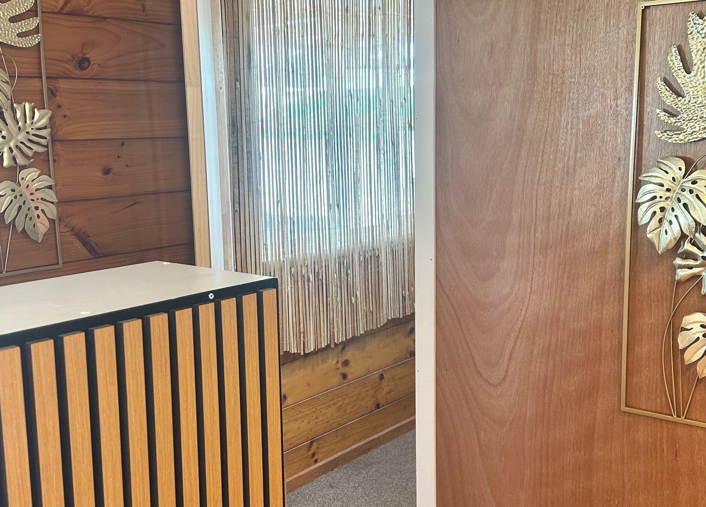 Elegant decor at Waipu Treatment Room, featuring wooden accents and gold leaf art, Waipu, Northland Region, NZ.