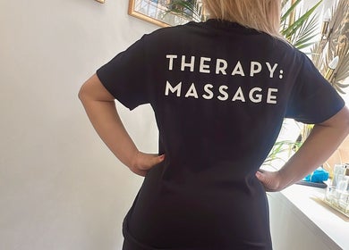 Back view of a staff member at Mol Thai Therapy, Doncaster, England, GB wearing a 'Therapy: Massage' shirt.
