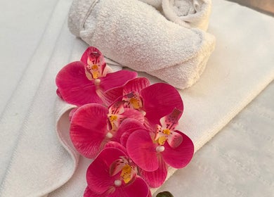 Pink orchids and rolled towels at Mol Thai Therapy, Doncaster, England, GB for a tranquil spa experience.