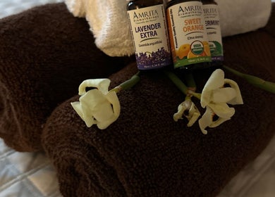 Essential oils and white flowers on plush towels at Adriatic Miracle Spa Massage, Folsom, California, US.