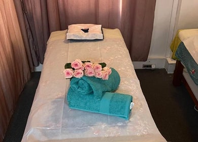 Cozy massage table with fresh roses at Magic Touch Thai Massage, The Rocks, New South Wales, AU.
