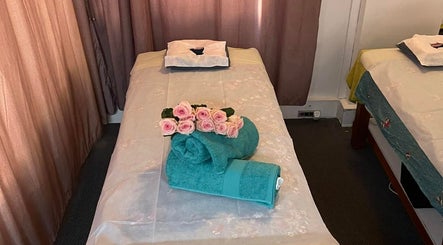 Cozy massage table with fresh roses at Magic Touch Thai Massage, The Rocks, New South Wales, AU.